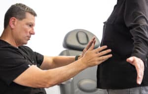 Dr. Eichenberg examinging a patient's chest for breast implant complications like rupture in Murrieta