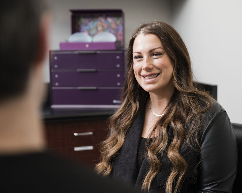 woman sitting in consultation with board certified plastic surgeon